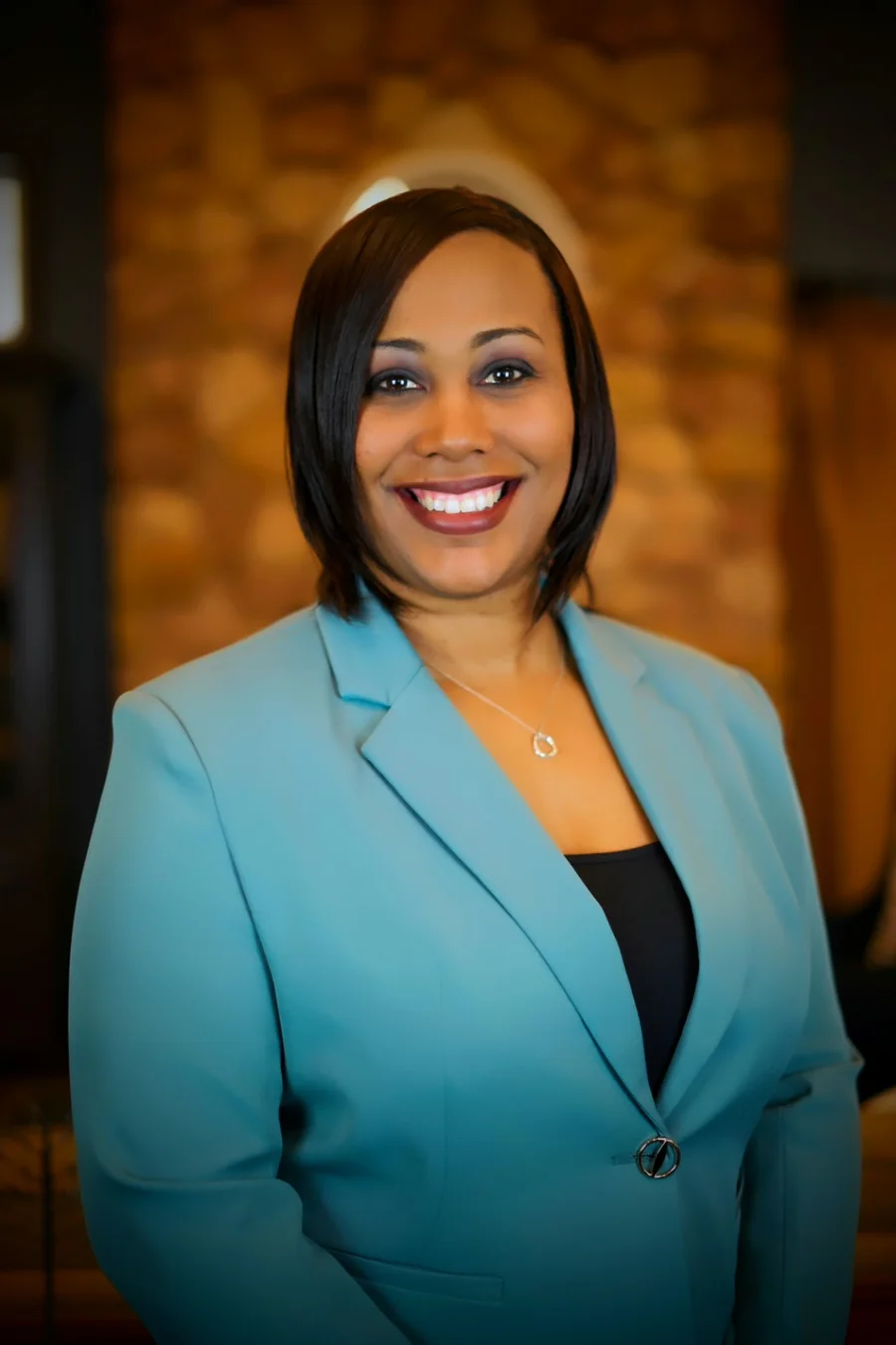 Portrait of Toni Knight smiling in a teal blazer